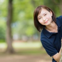 木の陰から見つめる女性